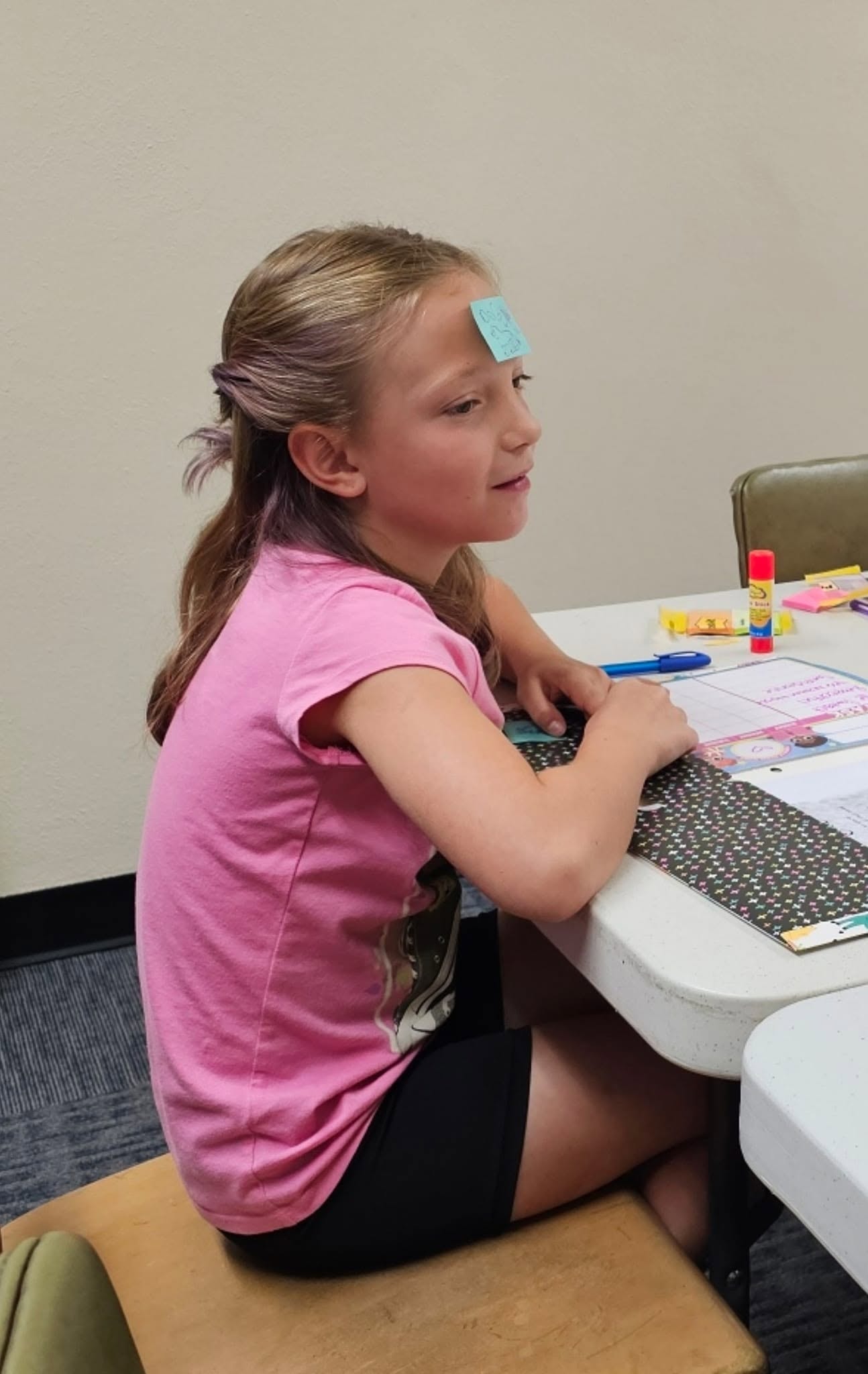 Girl with a sticky note on her forehead during a class game