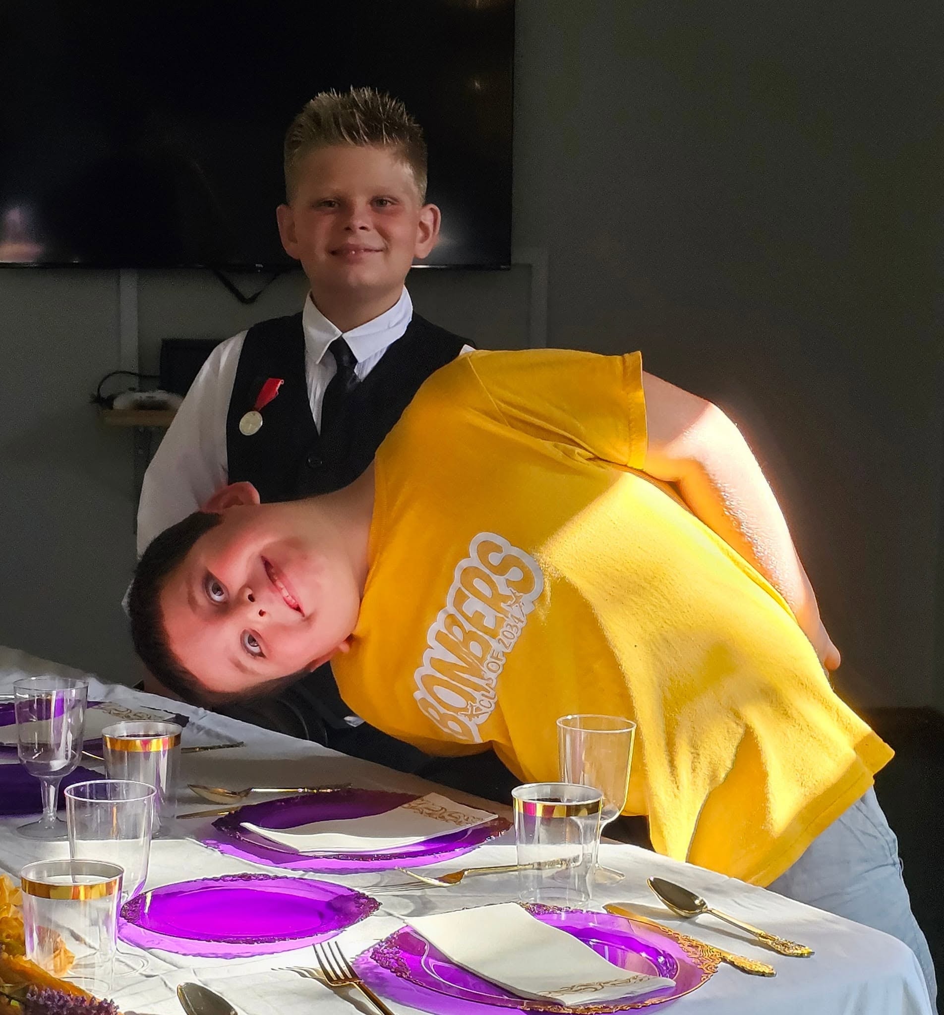 Two boys having fun at the formal etiquette dinner table