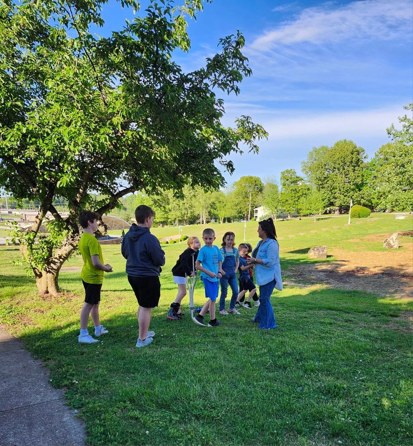 Students and instructor gathered for an outdoor class activity at the park
